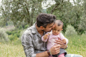 Father kissing baby girl in garden, Florence, Italy Father kissing baby girl in garden, Florence, Italy